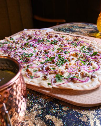 Classic Unser Classic Flammkuchen mit Tiroler Tiroler Bio-Speck, Zwiebeln und Petersil.